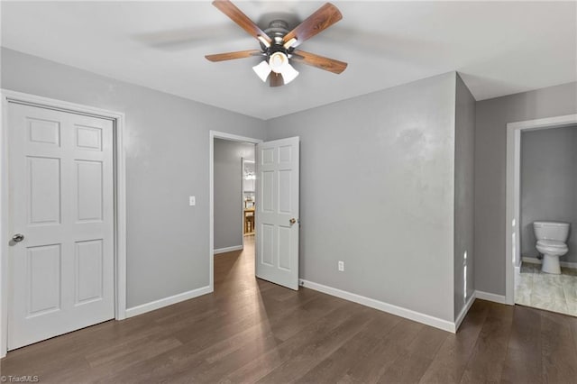 unfurnished bedroom featuring dark wood-type flooring, ceiling fan, and ensuite bathroom