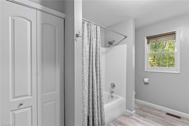 bathroom featuring shower / bathtub combination with curtain and wood-type flooring