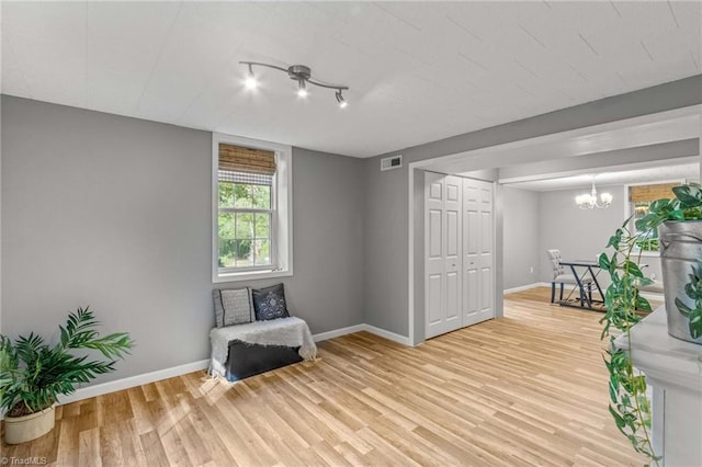 living area with an inviting chandelier and light wood-type flooring