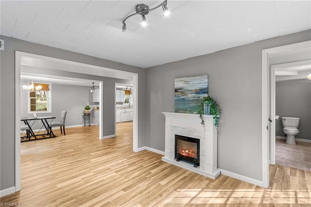 living room featuring light hardwood / wood-style flooring and ceiling fan with notable chandelier