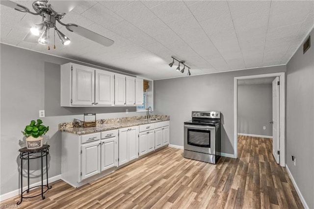 kitchen with light hardwood / wood-style flooring, white cabinets, and electric stove