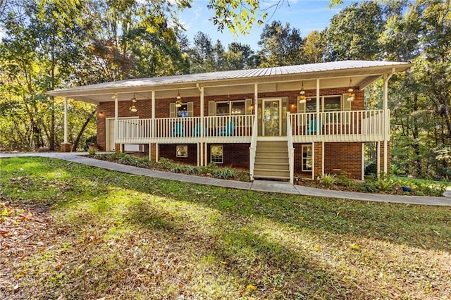 view of front of home featuring a wooden deck, ceiling fan, and a front lawn