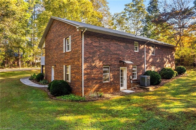 rear view of house featuring a lawn and cooling unit