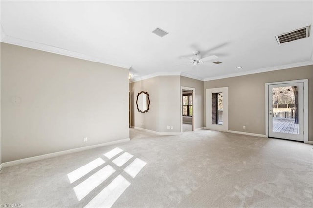 carpeted empty room featuring ceiling fan, crown molding, and a healthy amount of sunlight