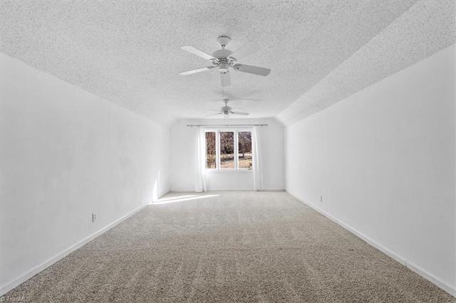 carpeted spare room with lofted ceiling, ceiling fan, and a textured ceiling