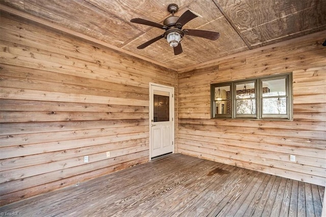 unfurnished room featuring hardwood / wood-style flooring, ceiling fan, wood ceiling, and wooden walls