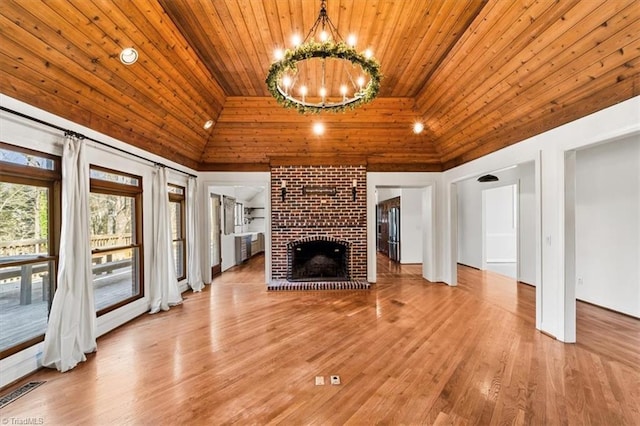 unfurnished living room with a brick fireplace, wooden ceiling, light wood-type flooring, high vaulted ceiling, and a chandelier