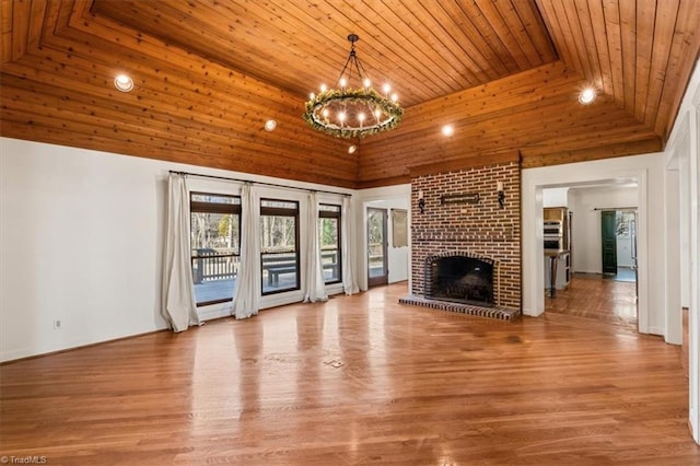 unfurnished living room featuring a fireplace, wood ceiling, a chandelier, and hardwood / wood-style floors