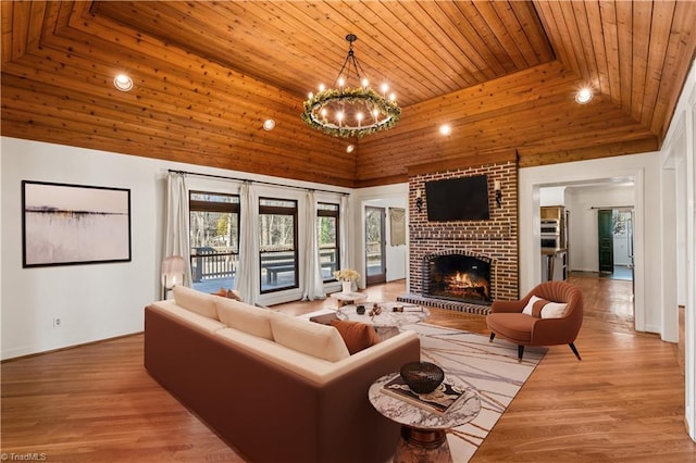 living room with a fireplace, wooden ceiling, light wood-type flooring, and an inviting chandelier