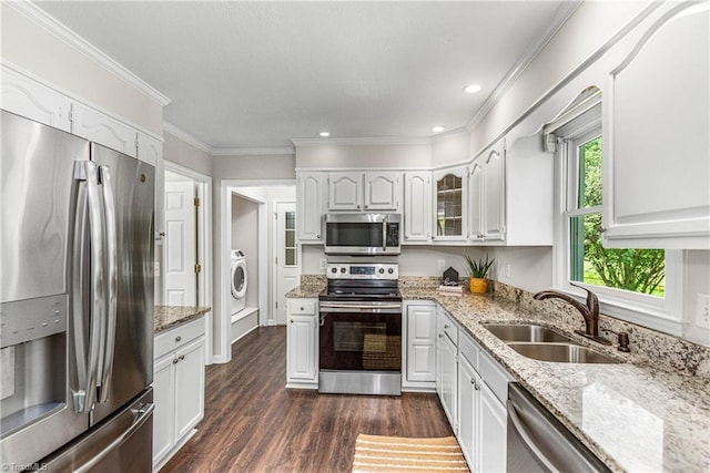 1556 Jubilee Trl, Kernersville, NC 27284 - kitchen featuring stainless steel appliances, washer / clothes dryer, light stone counters, dark wood-type flooring, and ornamental molding