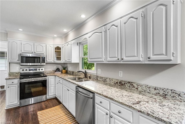 1556 Jubilee Trl, Kernersville, NC 27284 - kitchen featuring appliances with stainless steel finishes, ornamental molding, dark wood-style floors, light stone counters, and white cabinets