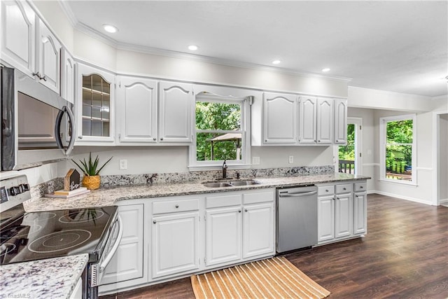 1556 Jubilee Trl, Kernersville, NC 27284 - kitchen with appliances with stainless steel finishes, healthy amount of natural light, ornamental molding, dark wood-style flooring, and white cabinetry