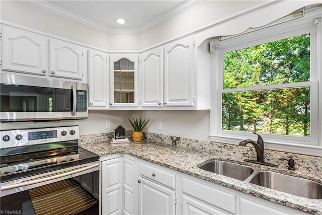 1556 Jubilee Trl, Kernersville, NC 27284 - kitchen featuring stainless steel appliances, healthy amount of natural light, white cabinets, light stone counters, and ornamental molding