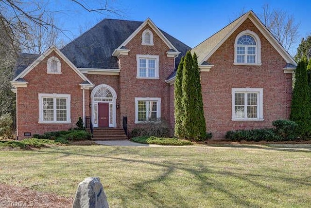 traditional home featuring brick siding and a front lawn