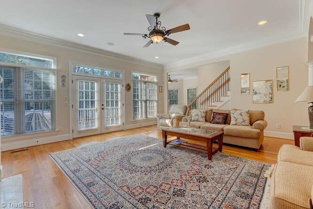 living area featuring crown molding, french doors, light wood-type flooring, and a wealth of natural light