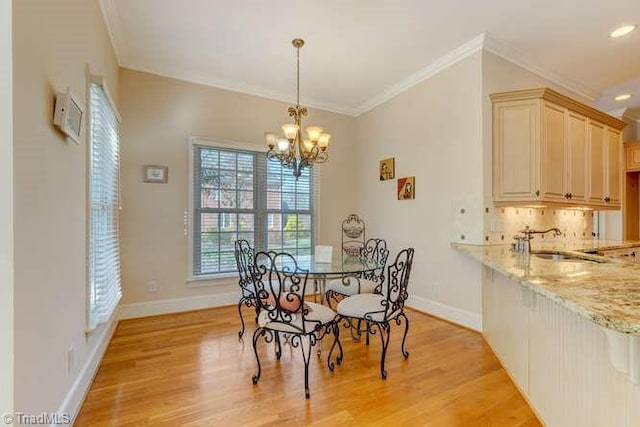 dining area with crown molding, baseboards, and light wood-type flooring