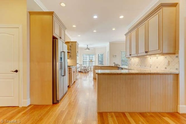 kitchen featuring a peninsula, ornamental molding, and high end refrigerator