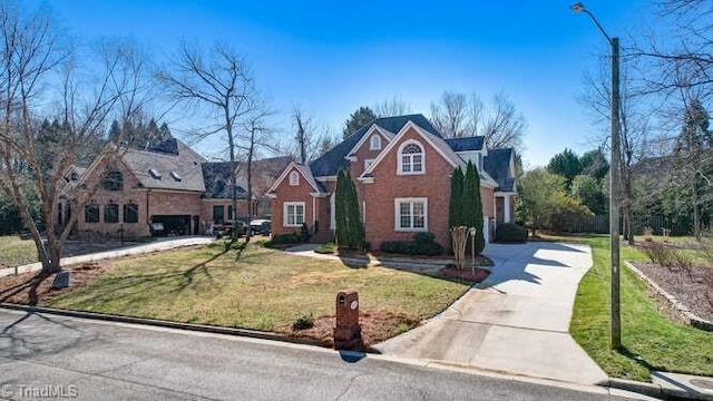 traditional-style house featuring concrete driveway and a front lawn