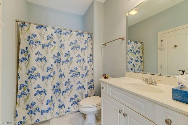 full bath with a shower with curtain, toilet, and vanity