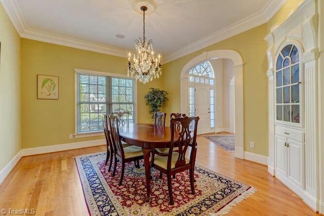 dining space with light wood-style flooring, baseboards, and ornamental molding