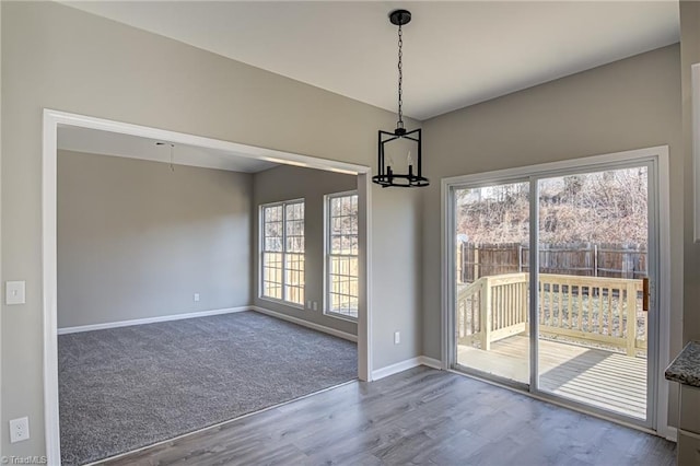 unfurnished dining area with hardwood / wood-style flooring and an inviting chandelier