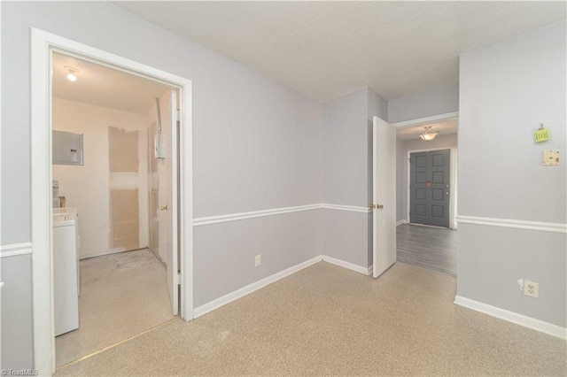 empty room with washer / clothes dryer, electric panel, baseboards, and carpet flooring