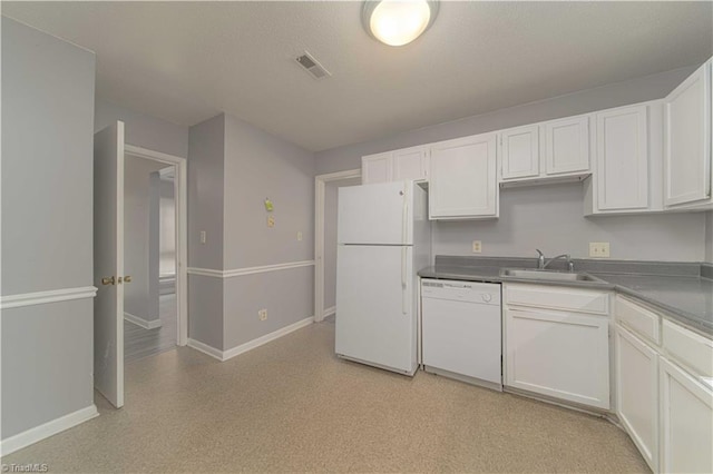 kitchen with white appliances, a sink, baseboards, and white cabinets
