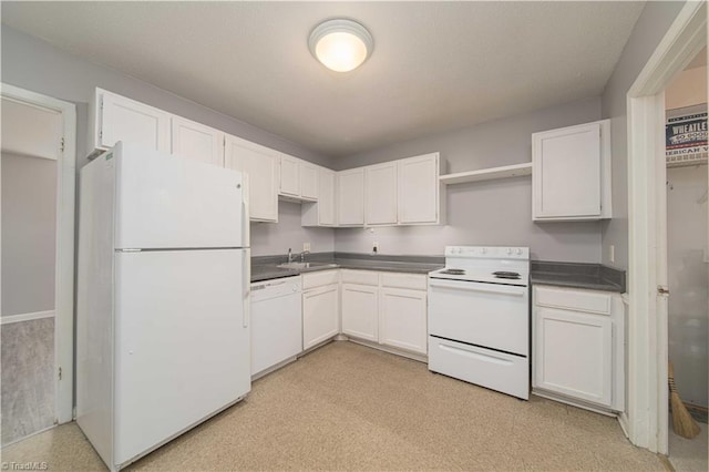 kitchen featuring white appliances, a sink, dark countertops, and open shelves