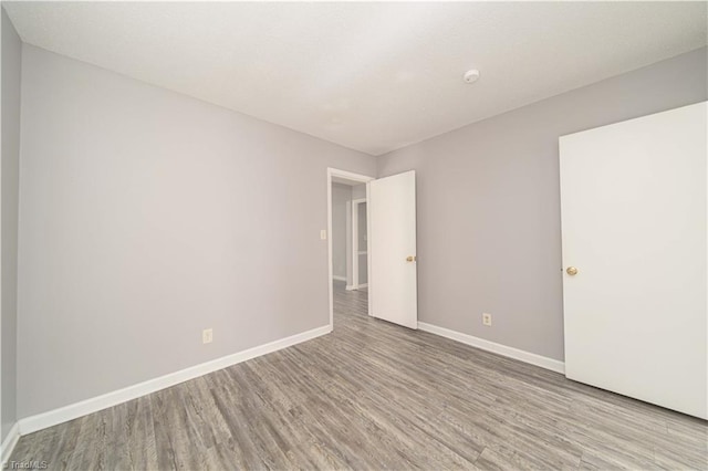 unfurnished room with wood finished floors and baseboards