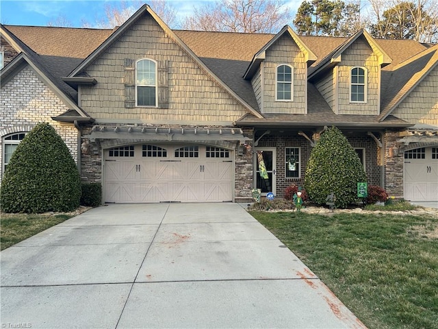 view of front of property with driveway, roof with shingles, and a front yard