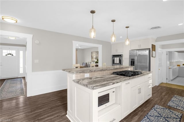 kitchen featuring a kitchen island, appliances with stainless steel finishes, white cabinetry, hanging light fixtures, and dark wood-type flooring