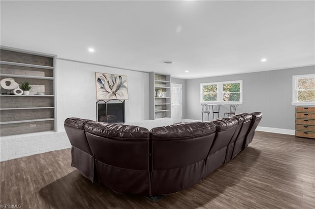 living room featuring dark hardwood / wood-style flooring and built in features