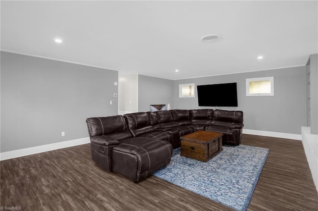 living room featuring a healthy amount of sunlight, dark wood-type flooring, and crown molding