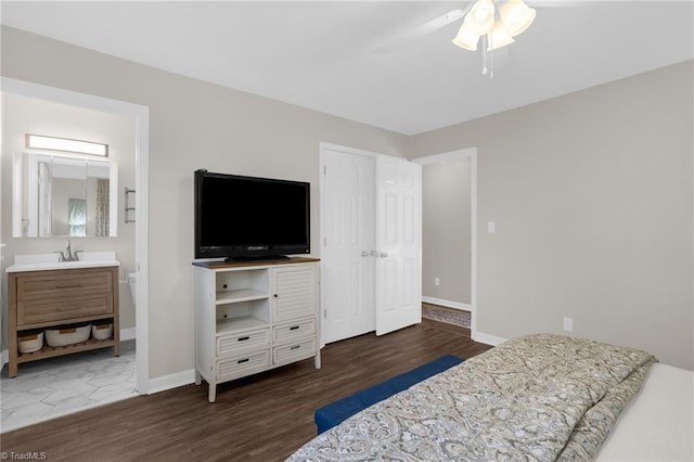 bedroom with ceiling fan, ensuite bath, dark hardwood / wood-style flooring, and sink