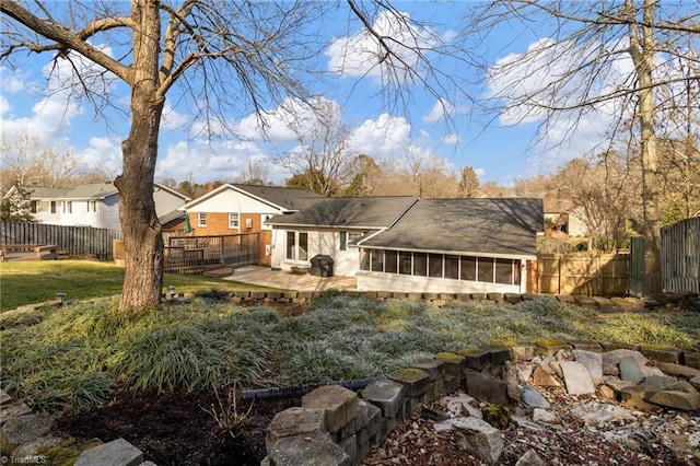 back of property featuring a sunroom and a patio area