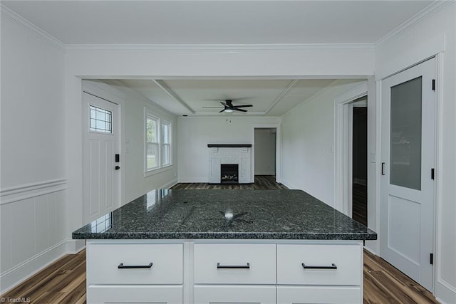 408 N Maple St, Graham, NC 27253 - kitchen with ceiling fan, dark wood-style floors, a brick fireplace, dark stone counters, and crown molding