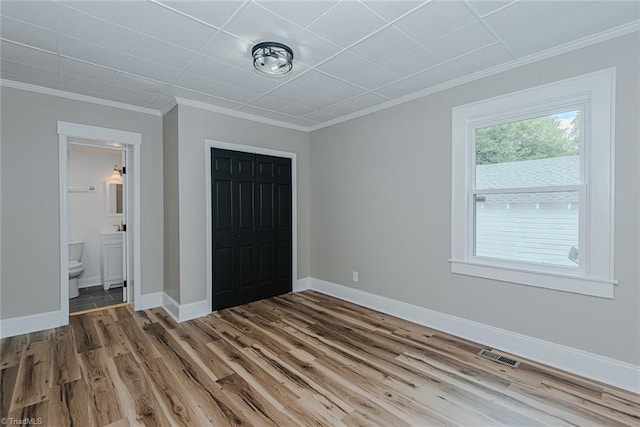 408 N Maple St, Graham, NC 27253 - unfurnished bedroom with wood finished floors, ornamental molding, a closet, baseboards, and ensuite bath