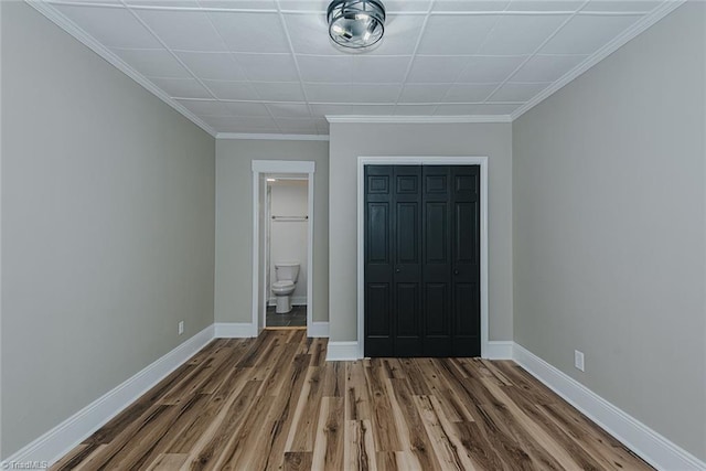 408 N Maple St, Graham, NC 27253 - unfurnished bedroom featuring wood finished floors, baseboards, crown molding, a closet, and ensuite bath