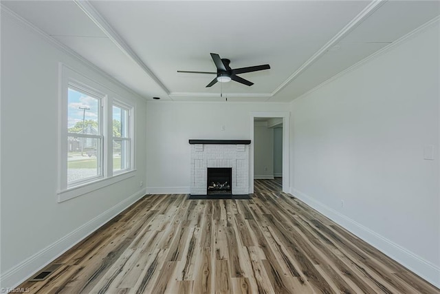 408 N Maple St, Graham, NC 27253 - unfurnished living room with wood finished floors, ceiling fan, a brick fireplace, and baseboards