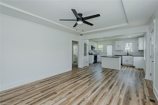 408 N Maple St, Graham, NC 27253 - unfurnished living room featuring light wood-type flooring, ceiling fan, crown molding, a sink, and baseboards