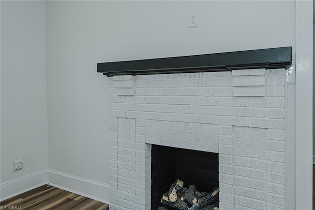 408 N Maple St, Graham, NC 27253 - detailed view of wood finished floors, a brick fireplace, and baseboards