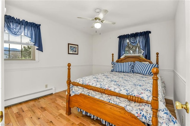 bedroom featuring ceiling fan, wood-type flooring, and baseboard heating