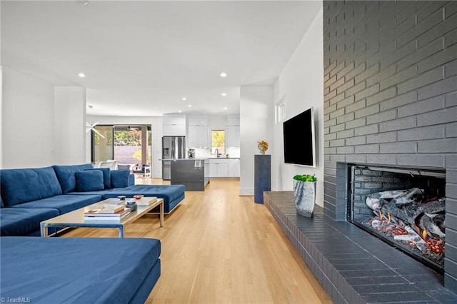 living room featuring light hardwood / wood-style floors and a brick fireplace