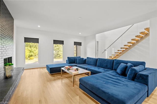 living room featuring light wood-type flooring and a brick fireplace