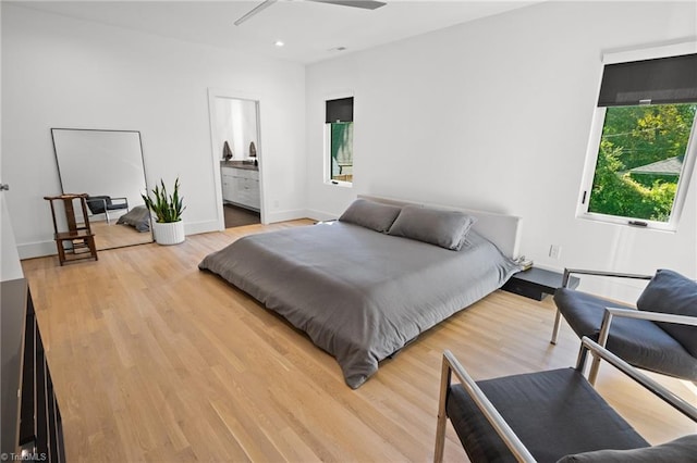 bedroom featuring ceiling fan, ensuite bathroom, and hardwood / wood-style flooring