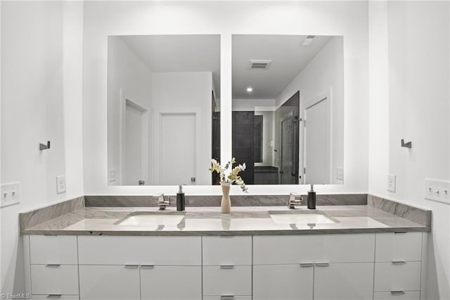 bathroom with a shower with door and vanity