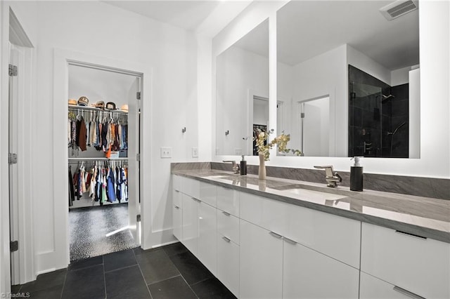 bathroom featuring a shower with door, vanity, and tile patterned floors