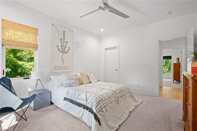 bedroom featuring light colored carpet and ceiling fan