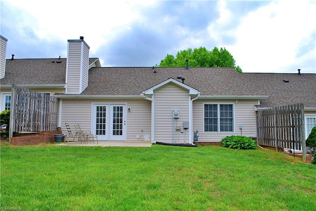 back of property with a yard, a patio, french doors, and a chimney