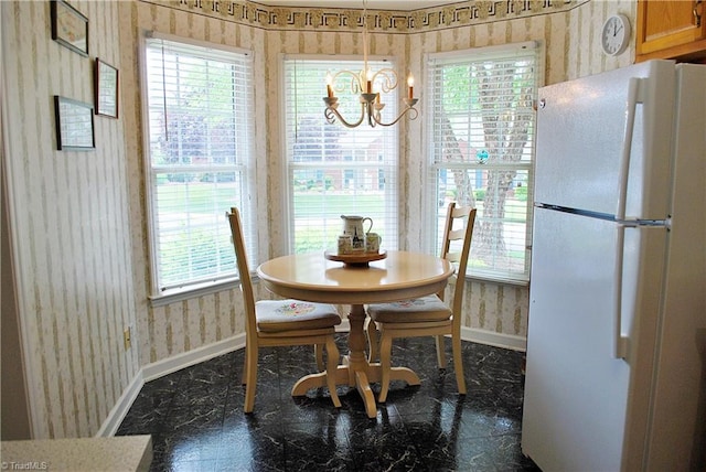 dining space with a healthy amount of sunlight, an inviting chandelier, baseboards, and wallpapered walls